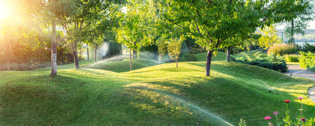 Irrigation sprinklers on hills with trees